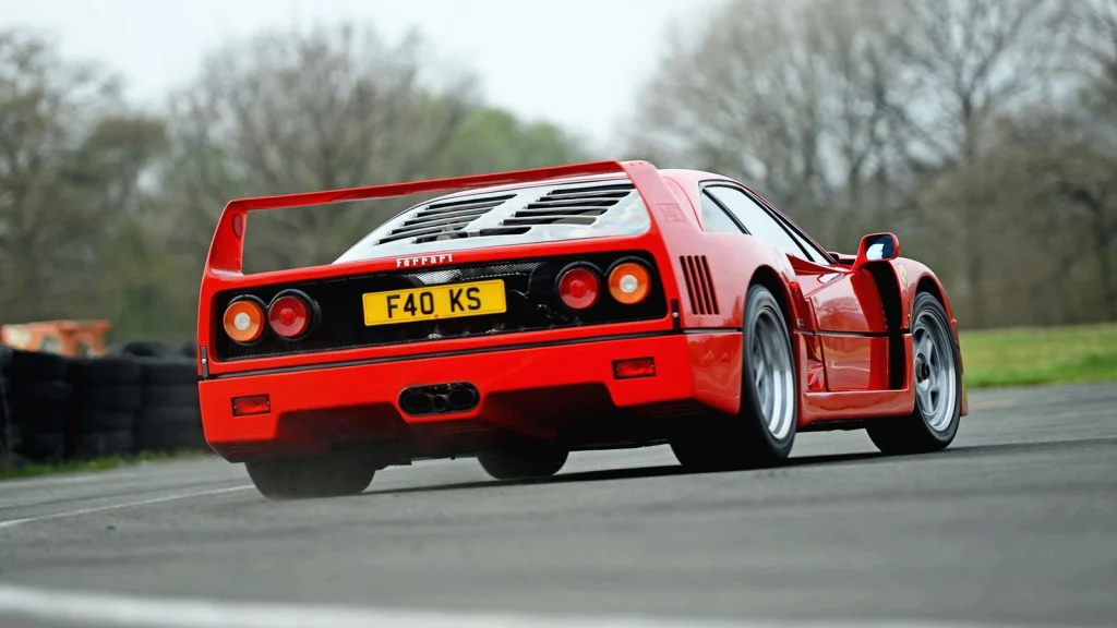 Ferrari F40 rouge vue de trois quarts arrière sur une piste