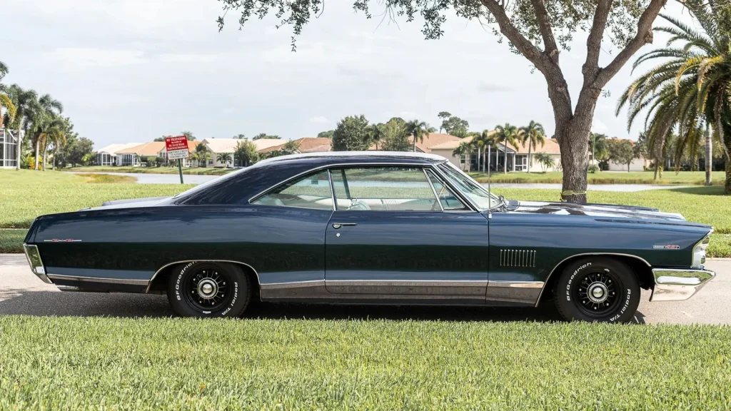 Pontiac Catalina 2+2 1965 bleu nuit vue de trois quarts avant sur une pelouse